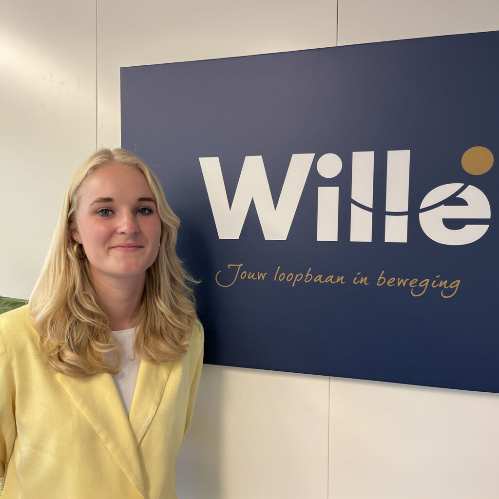 Leandra Ligthart staat voor een muur met het boord van Wille voor je loopbaan op de achtergrond.